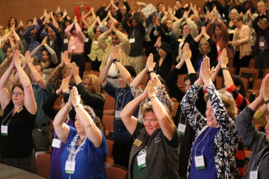 Shoreline Community College employees show "'phins up" during convocation in the theater, Wednesday, Sept. 16, 2015.