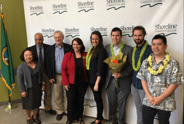 Members of the Board of Trustees and faculty members stand in a row posing for camera.