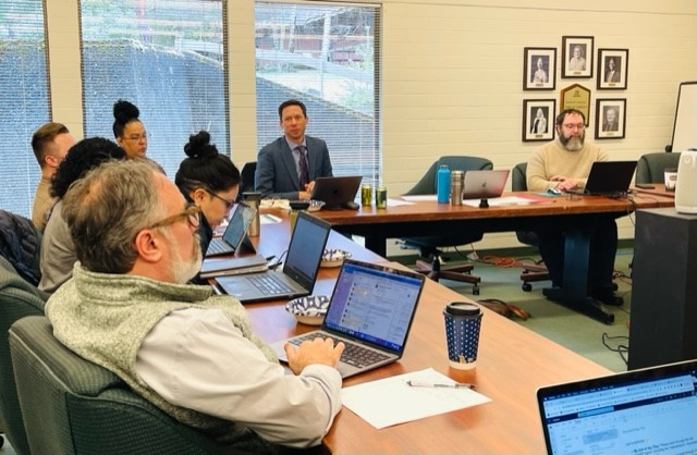 Accreditation Training group photo in training room with laptops and conference tables
