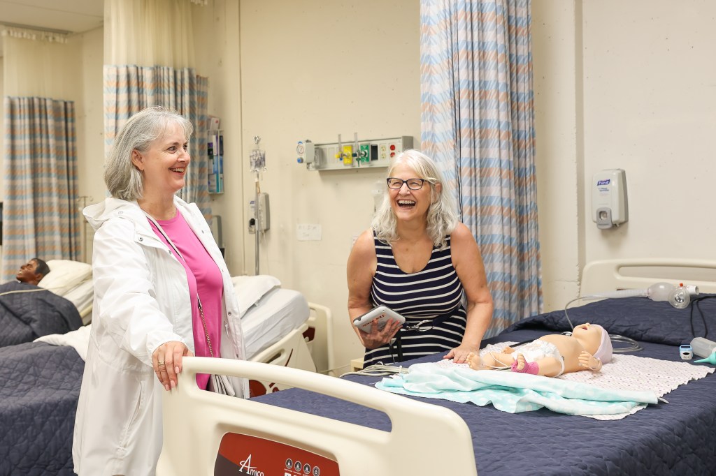 Representative Kloba and Mary Burroughs laughing by robotic baby