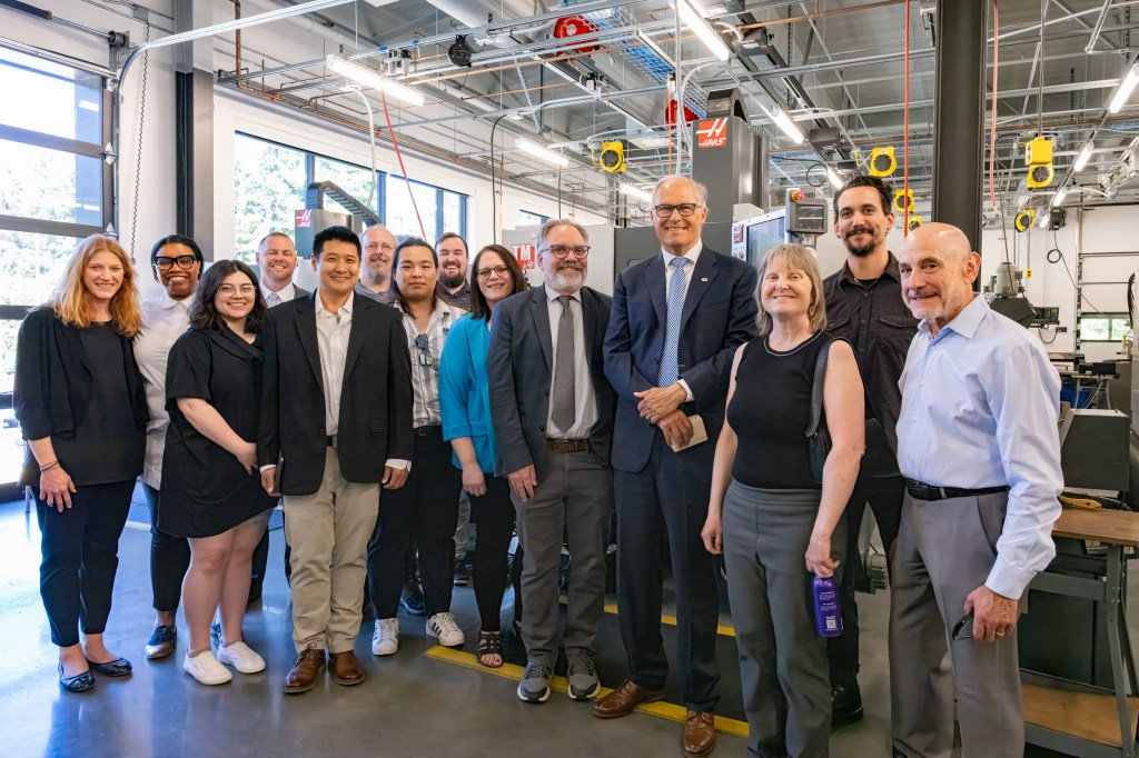 This is an image of several faculty and students posing in a picture with Governor Inslee in the Manufacturing Lab in the Cedar Building.