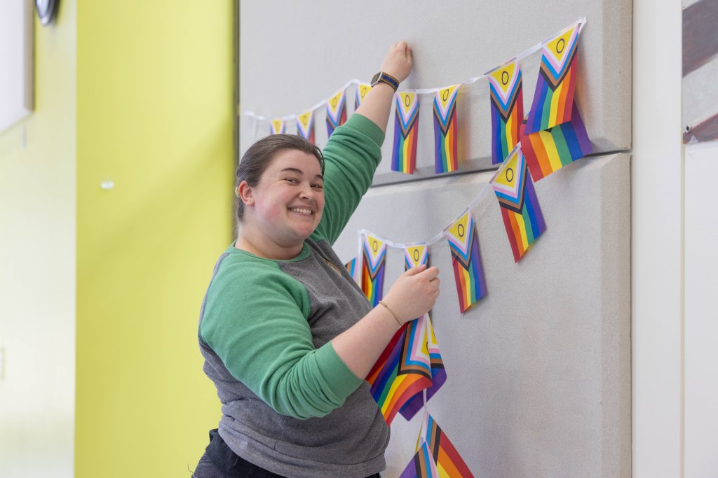 Person putting up Pride Flags
