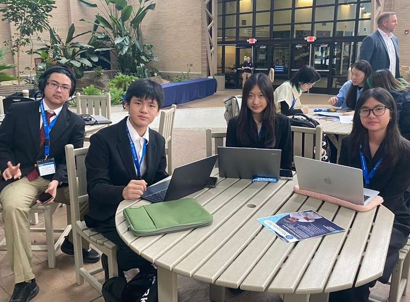 4 students seated at a table.