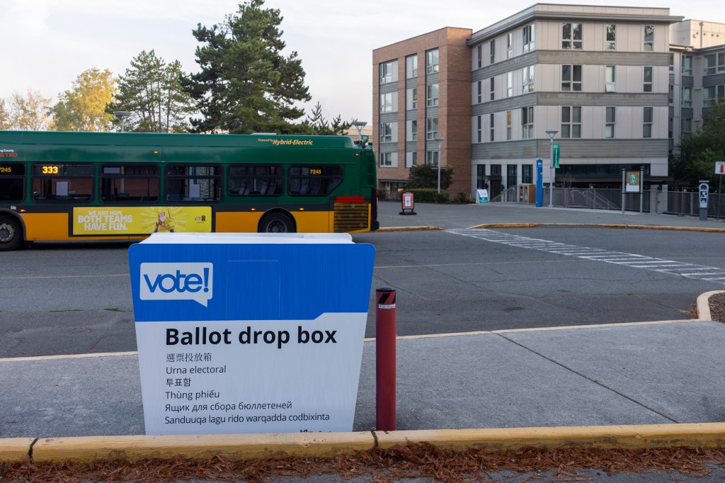 Photo of ballot box with the residence hall in the background. 